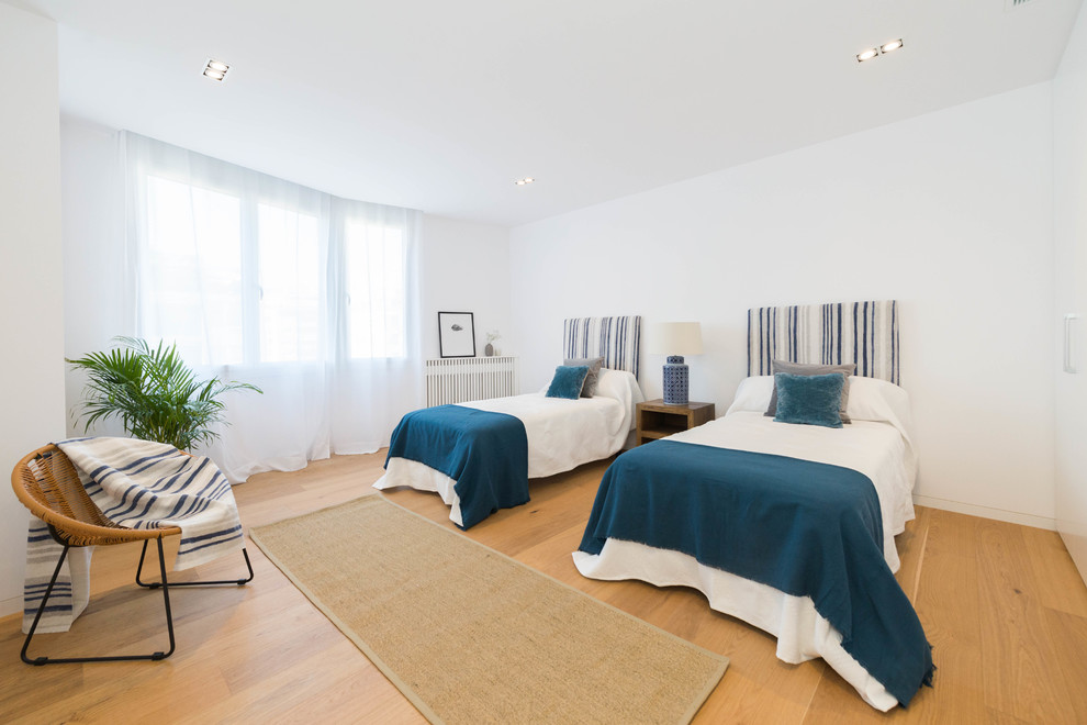 На фото: спальня в средиземноморском стиле с белыми стенами и паркетным полом среднего тона с