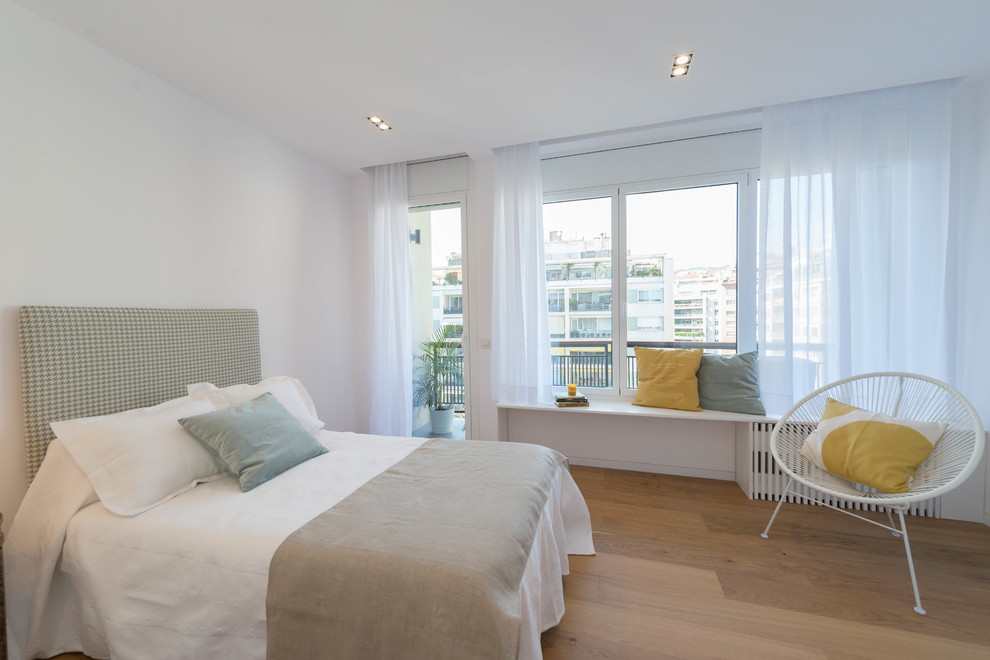 Modelo de habitación de invitados contemporánea con paredes blancas y suelo de madera en tonos medios