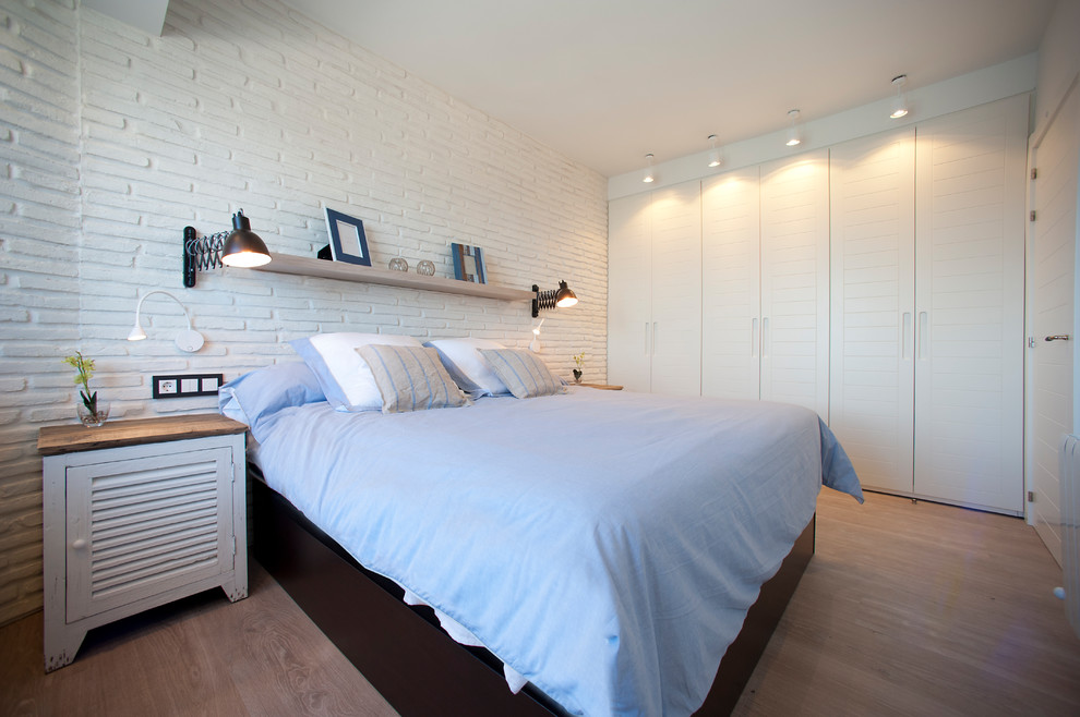 Imagen de habitación de invitados marinera pequeña con paredes blancas y suelo laminado