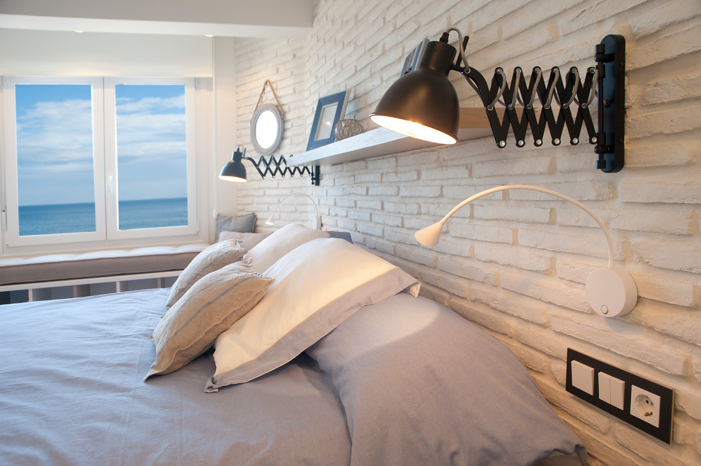 Imagen de dormitorio principal costero pequeño con paredes blancas y suelo laminado