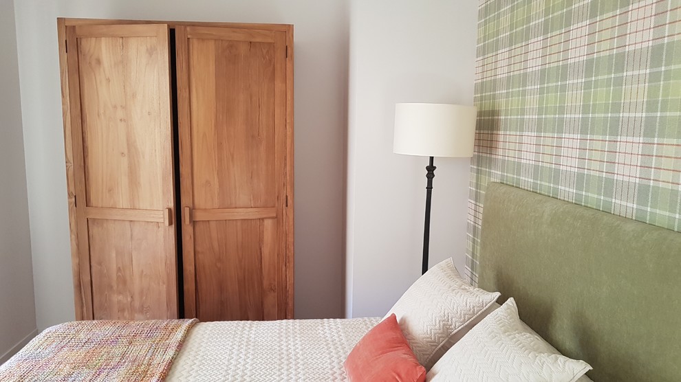 Imagen de habitación de invitados actual con paredes verdes y suelo de madera clara