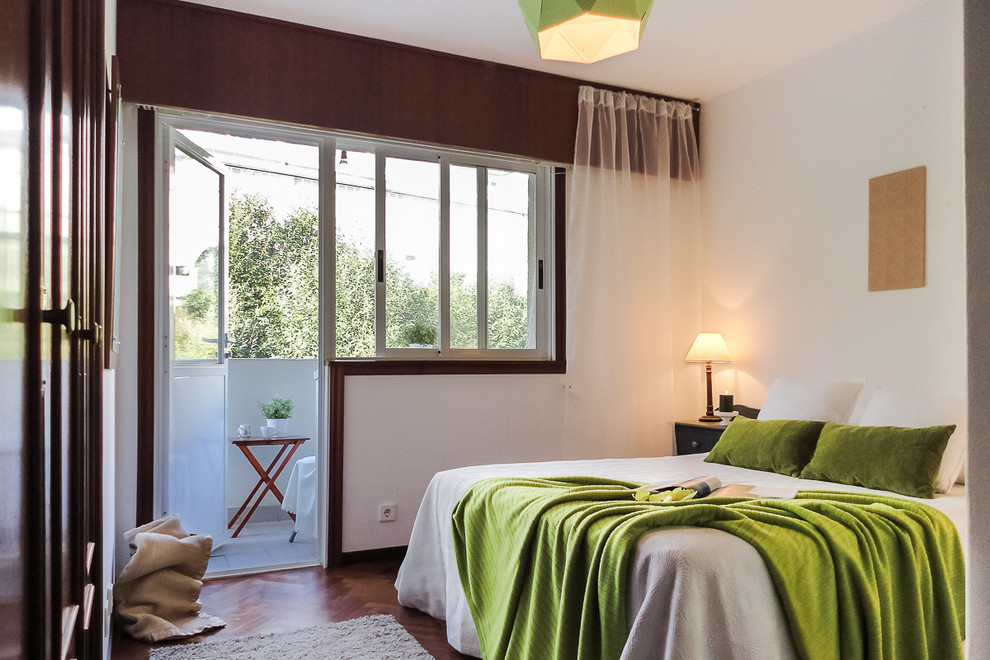 Example of a mid-sized transitional guest medium tone wood floor bedroom design in Other with white walls and no fireplace