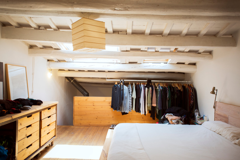 Diseño de dormitorio tipo loft mediterráneo de tamaño medio sin chimenea con paredes blancas y suelo de madera clara