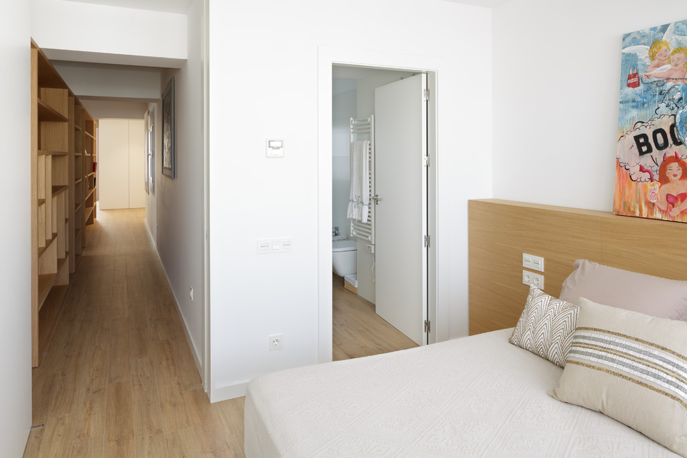 Exemple d'une chambre parentale moderne avec un mur blanc, un sol en bois brun et un sol marron.