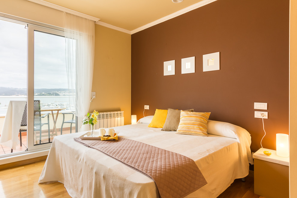 Ejemplo de dormitorio principal tradicional renovado de tamaño medio sin chimenea con paredes marrones y suelo de madera en tonos medios