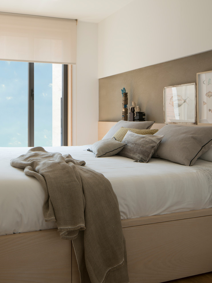 Modelo de dormitorio principal clásico renovado de tamaño medio con paredes blancas, suelo de madera en tonos medios y suelo marrón