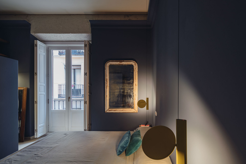 Modernes Hauptschlafzimmer mit blauer Wandfarbe, Betonboden und beigem Boden in Madrid