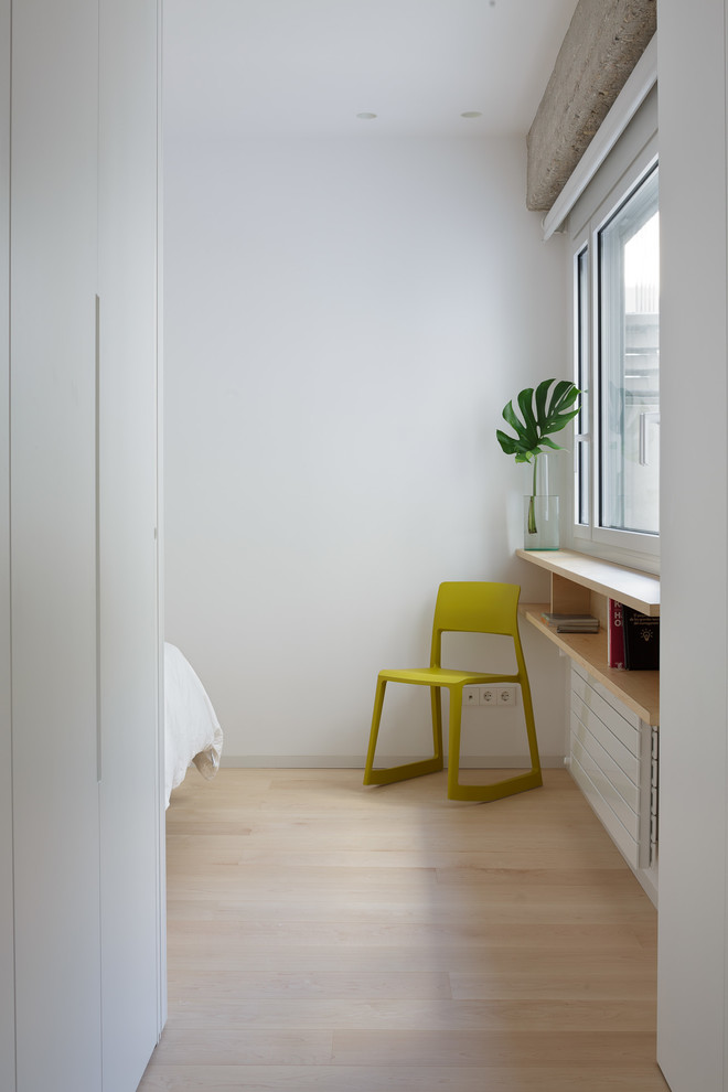Cette photo montre une chambre parentale moderne avec un mur blanc et parquet clair.
