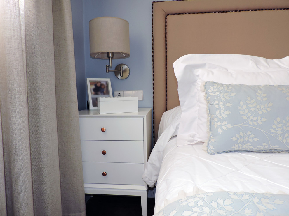 Modelo de dormitorio principal clásico de tamaño medio con paredes azules y suelo de madera oscura