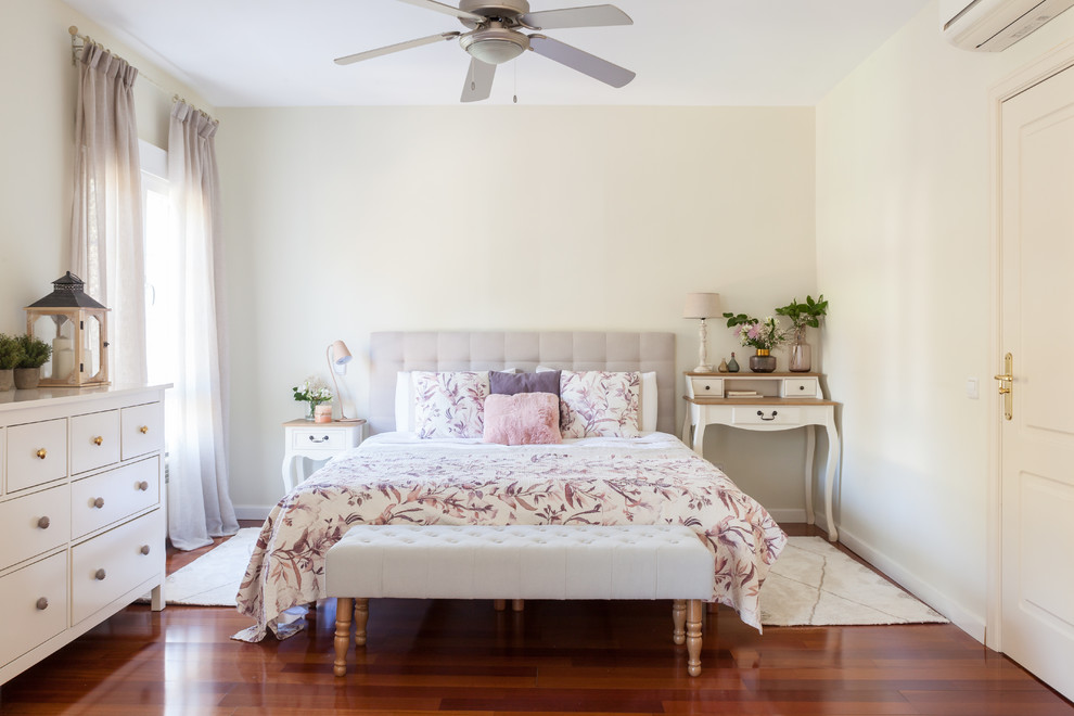 Imagen de dormitorio romántico con paredes beige, suelo de madera en tonos medios y suelo marrón