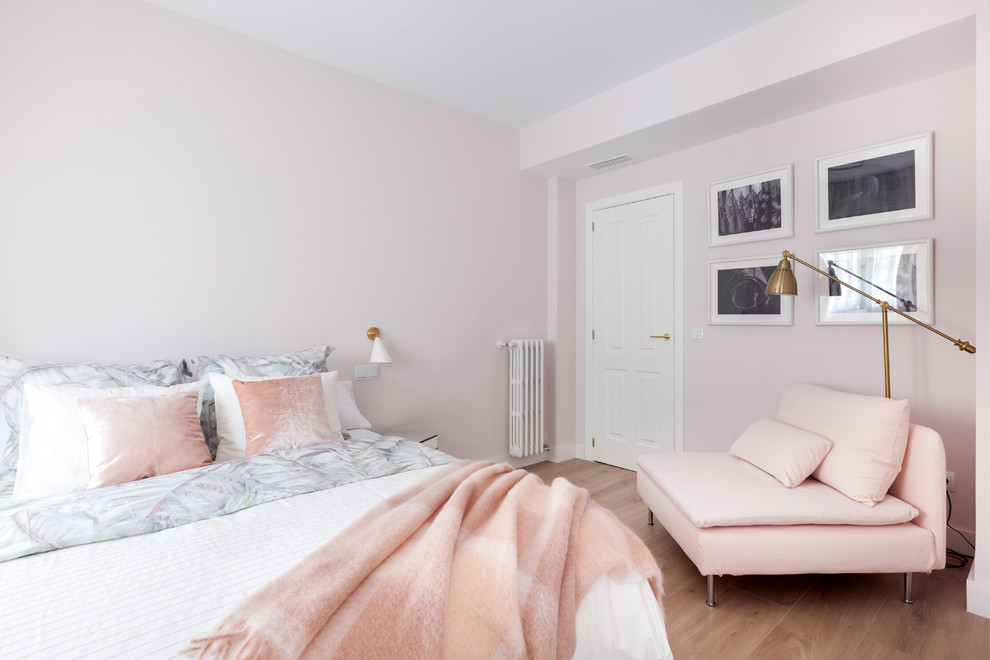 This is an example of a classic master and grey and pink bedroom in Madrid with pink walls and medium hardwood flooring.