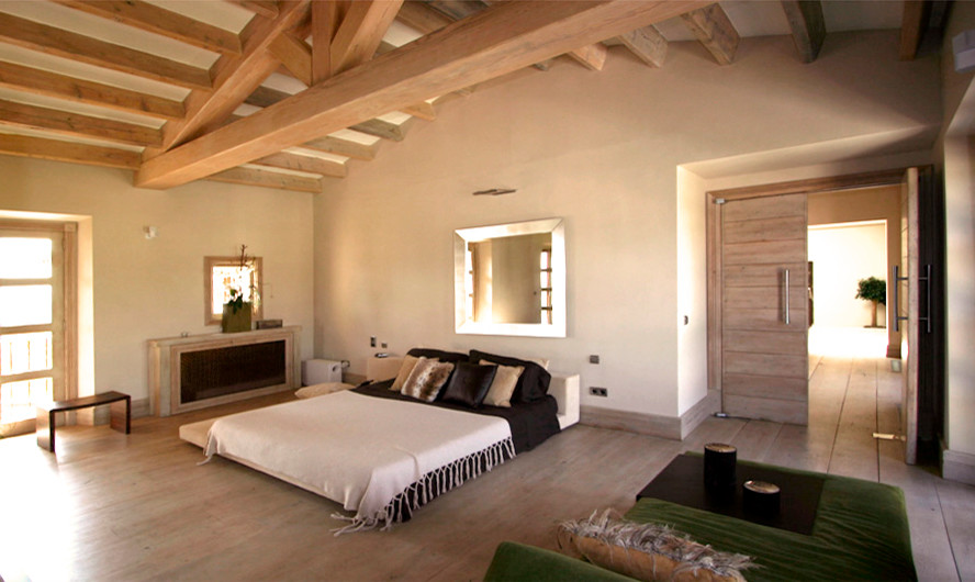 Ejemplo de dormitorio principal rústico grande con paredes blancas, suelo de madera clara y suelo beige