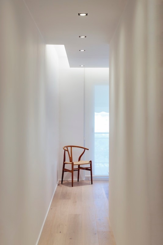 Modelo de dormitorio principal minimalista de tamaño medio con paredes blancas y suelo de madera clara