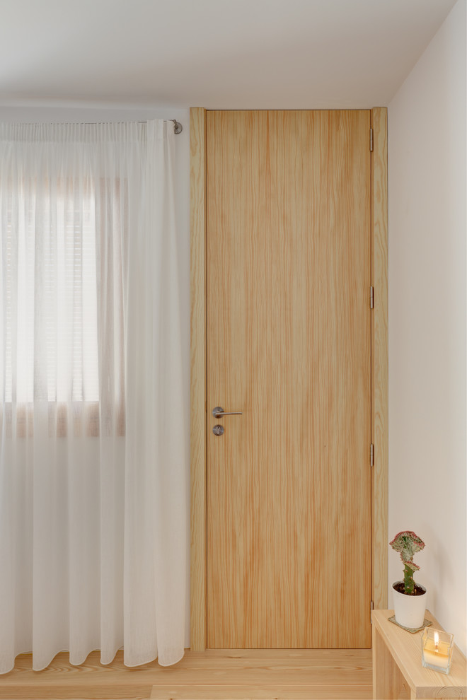 Imagen de dormitorio principal actual con suelo de madera clara