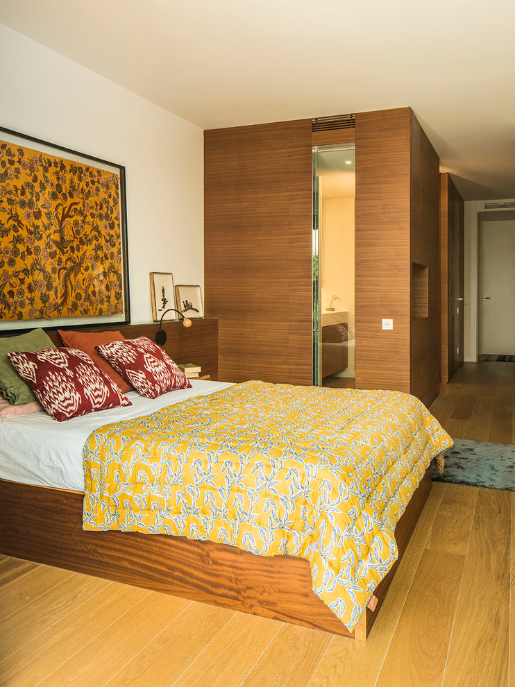 Großes Modernes Hauptschlafzimmer ohne Kamin mit weißer Wandfarbe, braunem Holzboden und braunem Boden in Barcelona