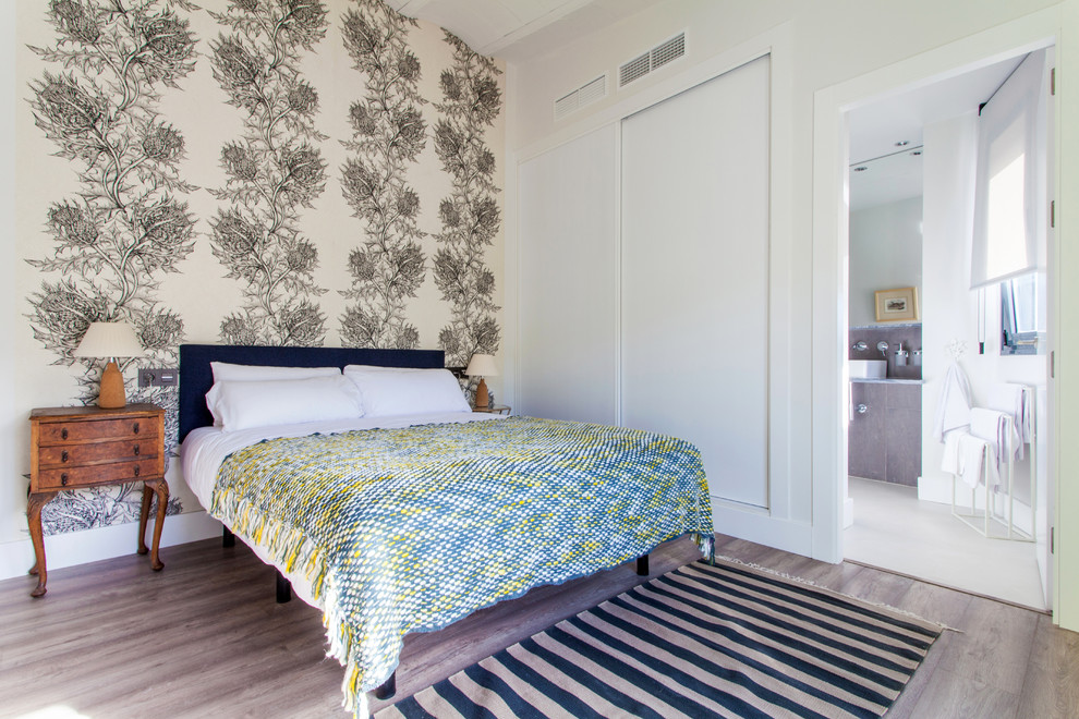 Ejemplo de dormitorio principal tradicional renovado de tamaño medio sin chimenea con paredes blancas y suelo de madera en tonos medios