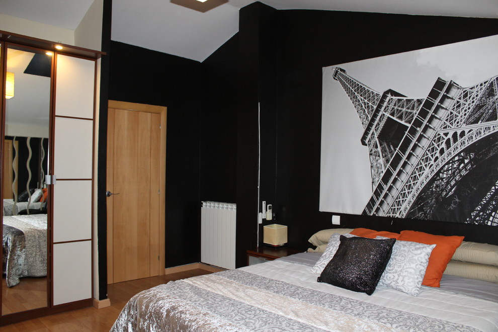 Imagen de dormitorio principal actual de tamaño medio sin chimenea con paredes negras