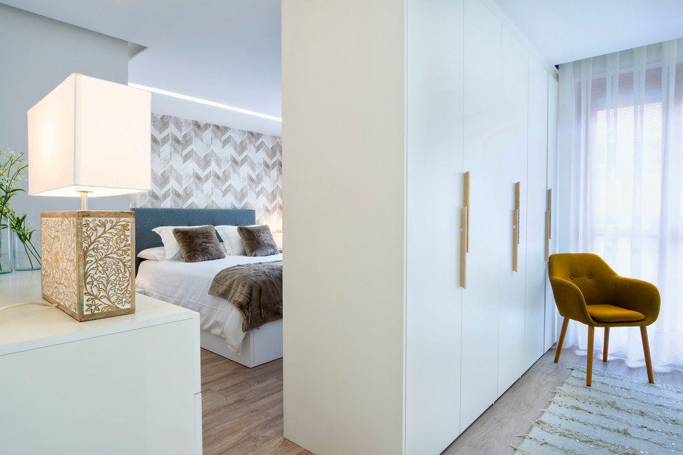 Foto di una camera matrimoniale contemporanea con pareti bianche, pavimento in legno massello medio e pavimento marrone