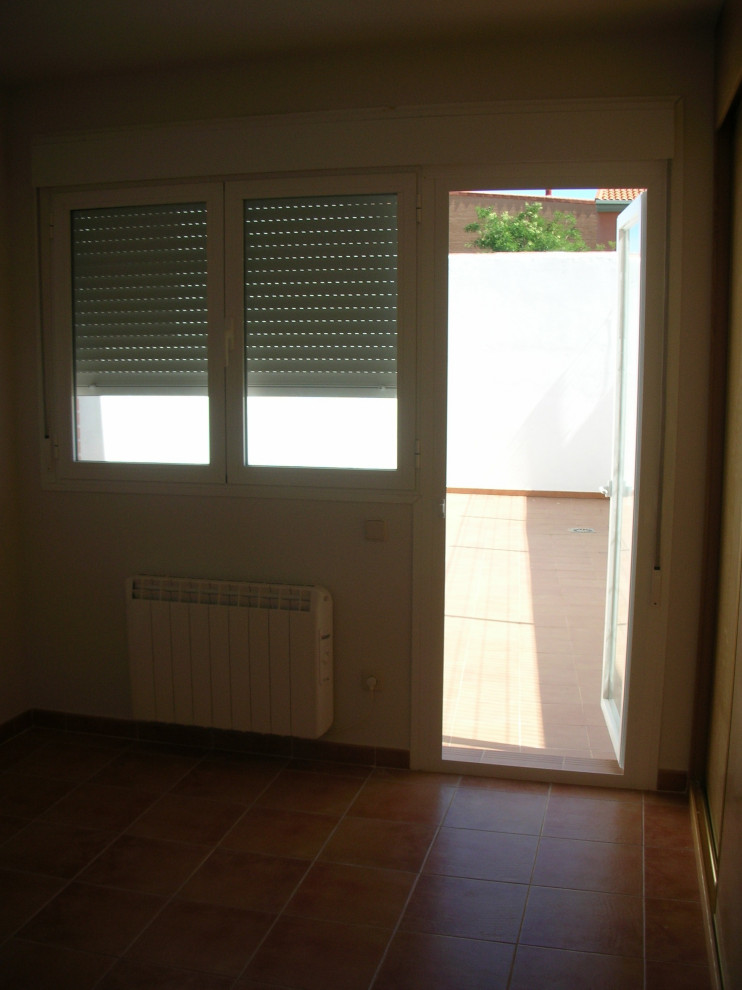 Ejemplo de dormitorio principal minimalista de tamaño medio con paredes blancas, suelo de baldosas de cerámica y suelo marrón