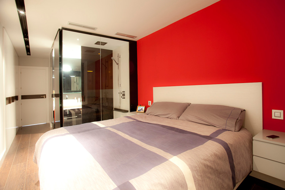 Réalisation d'une chambre parentale design de taille moyenne avec un mur rouge, un sol en bois brun et aucune cheminée.