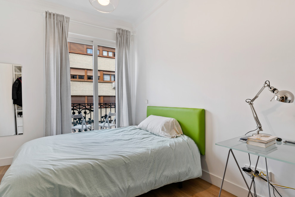 Diseño de dormitorio principal clásico renovado de tamaño medio con paredes blancas, suelo de madera en tonos medios y suelo marrón