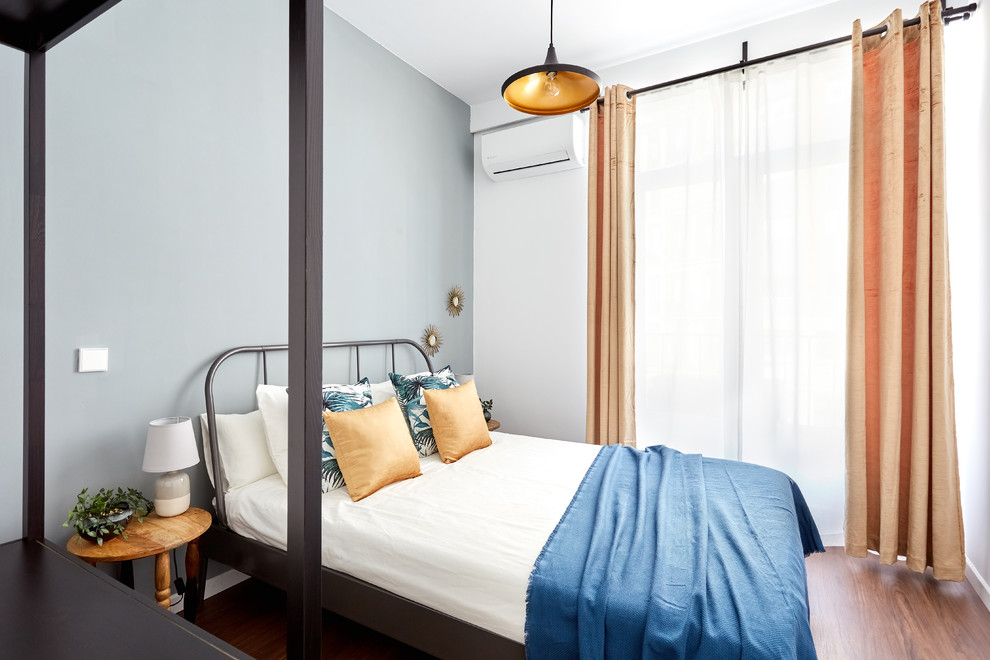 マドリードにある小さなコンテンポラリースタイルのおしゃれな客用寝室 (濃色無垢フローリング、白い壁、茶色い床)