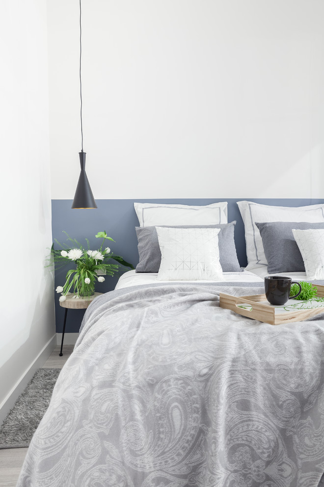 Foto de dormitorio principal escandinavo de tamaño medio con paredes blancas, suelo laminado y suelo gris