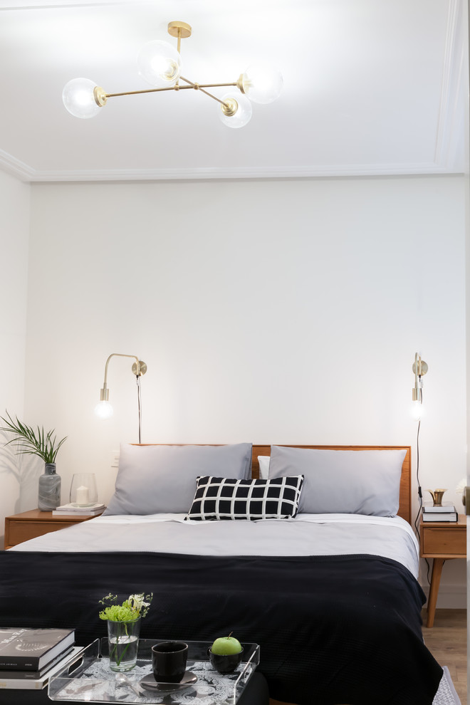 Ejemplo de dormitorio principal escandinavo de tamaño medio con paredes blancas y suelo de madera oscura