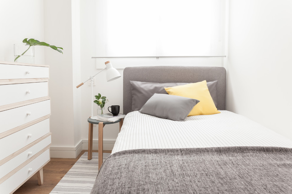 マドリードにある小さなコンテンポラリースタイルのおしゃれな客用寝室 (白い壁、無垢フローリング、茶色い床、グレーとブラウン)