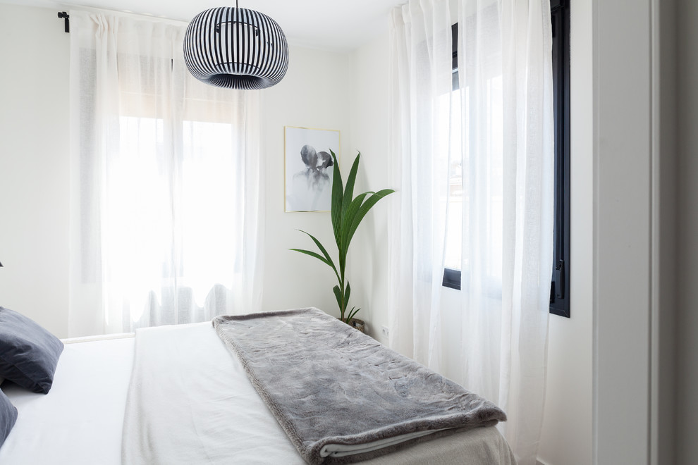 Стильный дизайн: хозяйская спальня среднего размера в скандинавском стиле с белыми стенами, полом из ламината и коричневым полом без камина - последний тренд