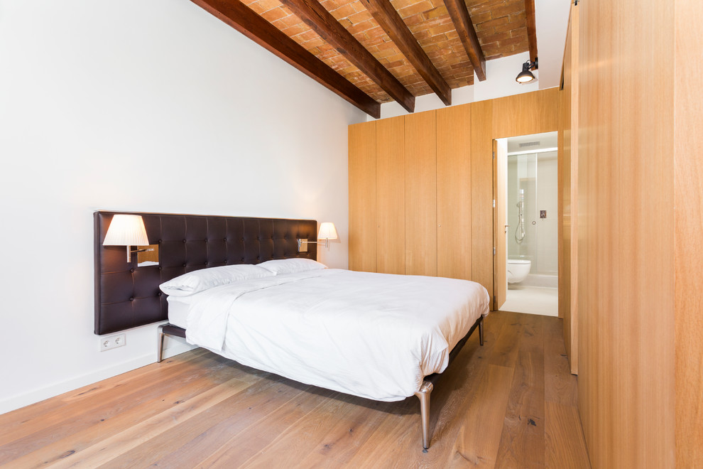 Ejemplo de dormitorio principal mediterráneo grande con paredes blancas y suelo de madera en tonos medios