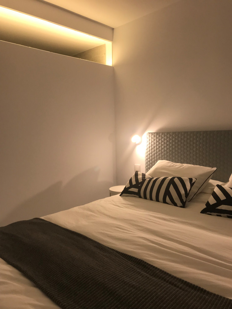 Стильный дизайн: хозяйская спальня в современном стиле с белыми стенами, полом из ламината и белым полом - последний тренд