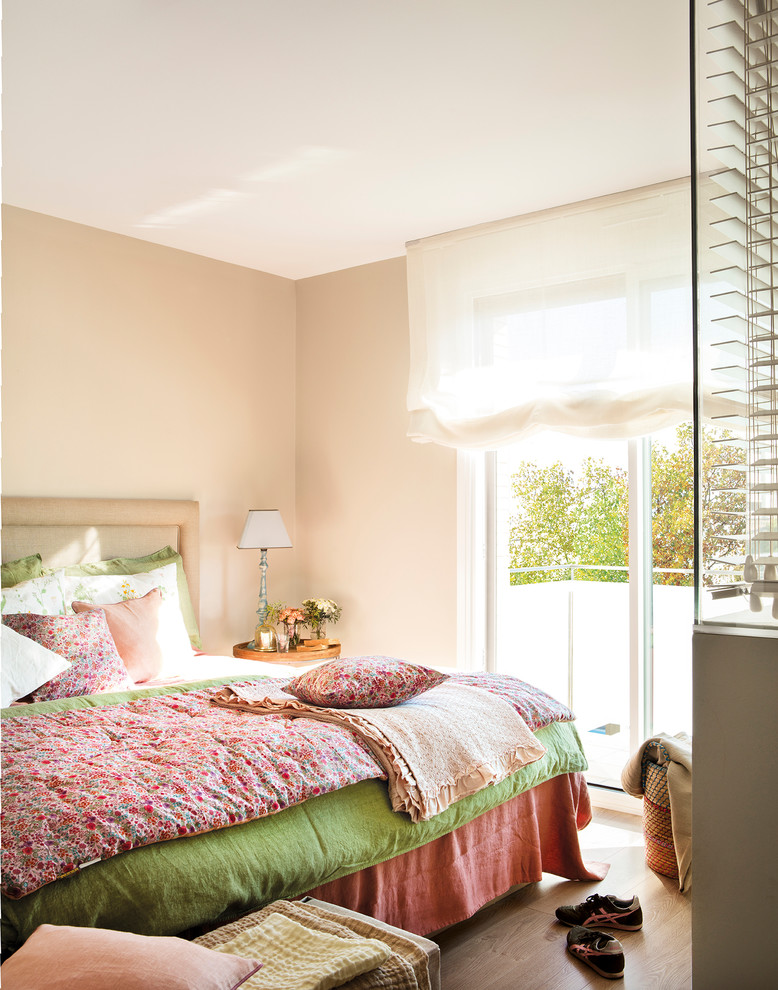 Cette photo montre une chambre parentale tendance de taille moyenne avec un mur beige, parquet clair et un sol beige.