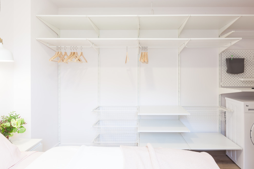 他の地域にある小さな北欧スタイルのおしゃれな主寝室 (白い壁、ラミネートの床、茶色い床) のインテリア