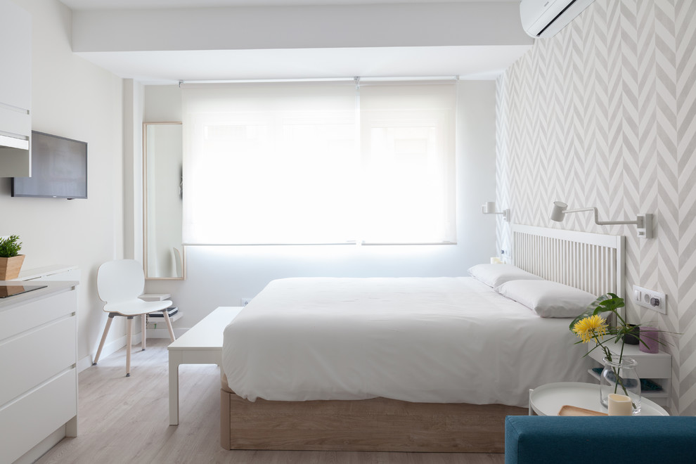 Inspiration for a small scandi master bedroom in Madrid with white walls, light hardwood flooring and beige floors.