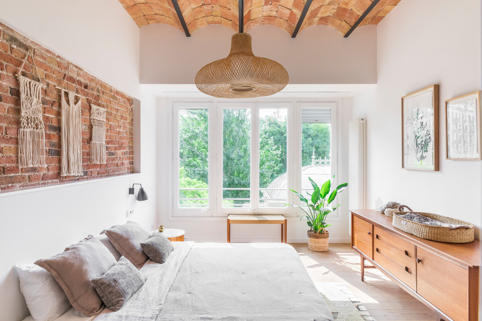Foto de dormitorio mediterráneo sin chimenea con paredes blancas, suelo de madera clara y suelo beige