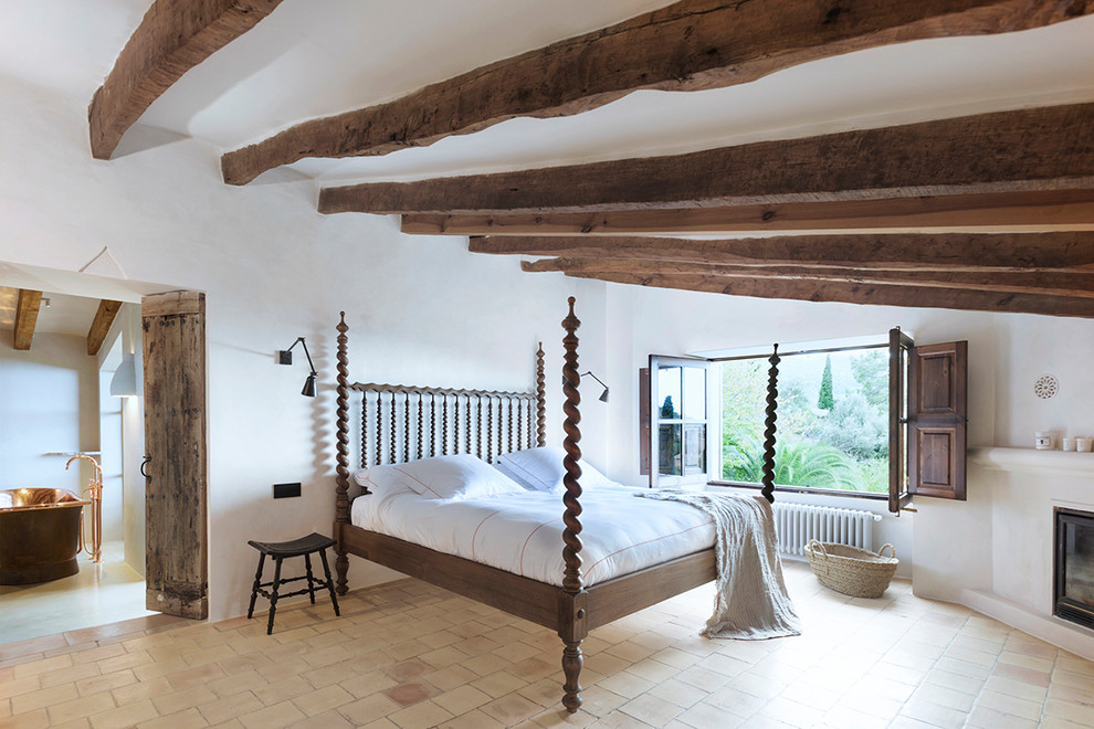 Пример оригинального дизайна: хозяйская спальня в средиземноморском стиле с белыми стенами, угловым камином, фасадом камина из штукатурки и бежевым полом