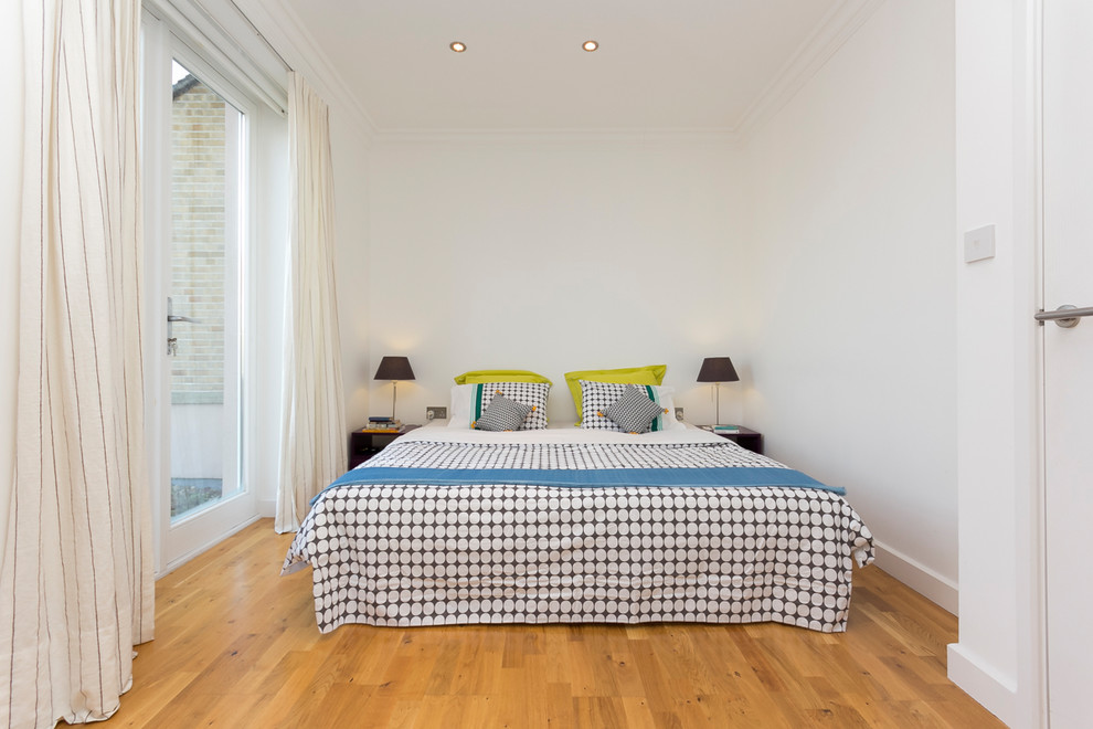 Diseño de dormitorio principal actual con suelo de madera en tonos medios