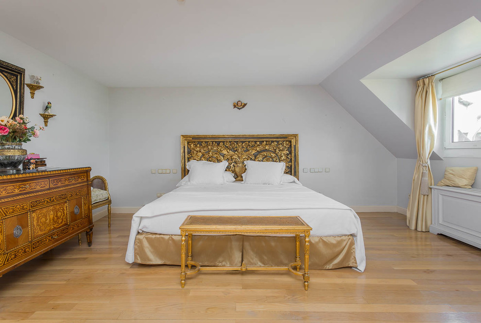 Foto de dormitorio principal clásico de tamaño medio con paredes blancas, suelo de madera clara y suelo beige