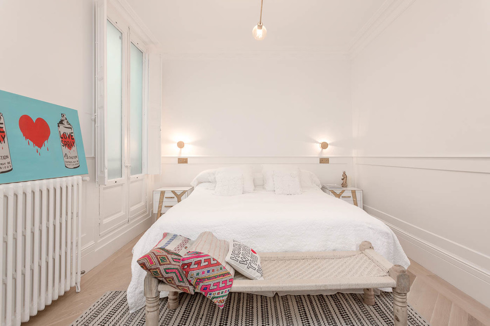 Ejemplo de dormitorio principal clásico renovado de tamaño medio con paredes blancas y suelo de madera clara