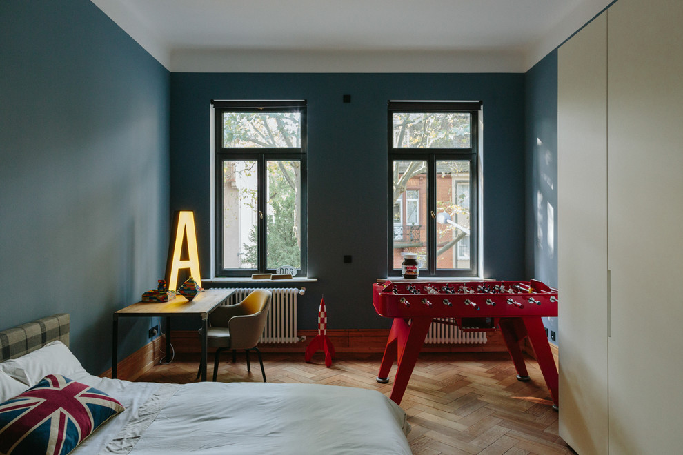 Ejemplo de dormitorio principal contemporáneo grande sin chimenea con paredes azules, suelo de madera en tonos medios y suelo marrón