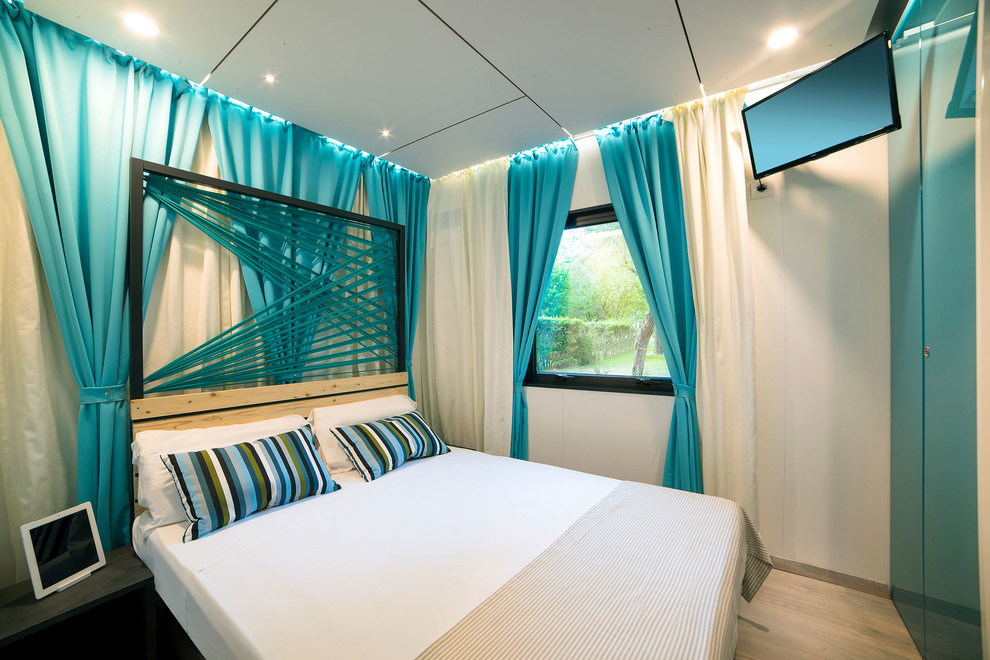 Идея дизайна: спальня в современном стиле с белыми стенами, светлым паркетным полом, бежевым полом и синими шторами