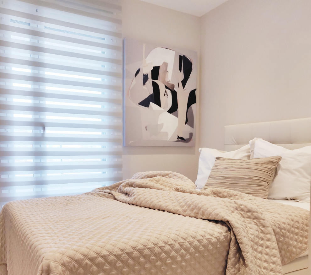 Imagen de habitación de invitados actual de tamaño medio con paredes beige y suelo de madera clara