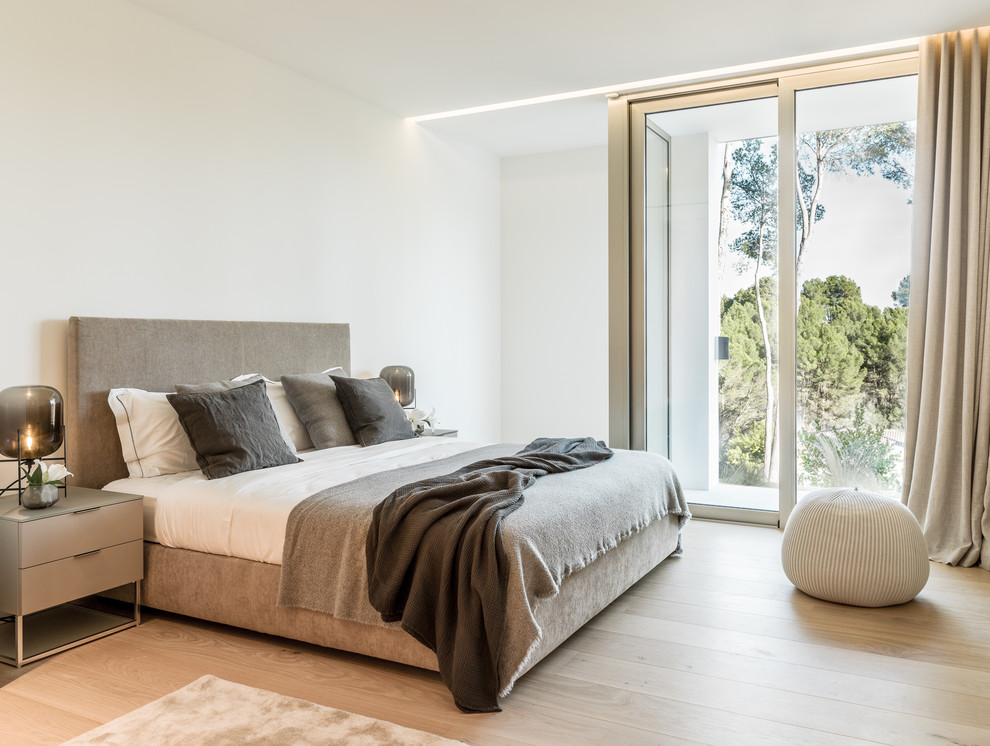 Design ideas for a medium sized contemporary master bedroom in Palma de Mallorca with white walls, medium hardwood flooring, no fireplace and brown floors.