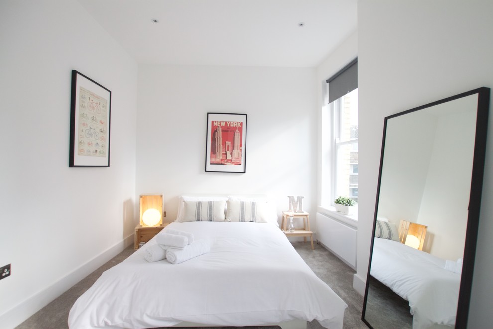 Skandinavisches Gästezimmer mit weißer Wandfarbe, Teppichboden und grauem Boden in London