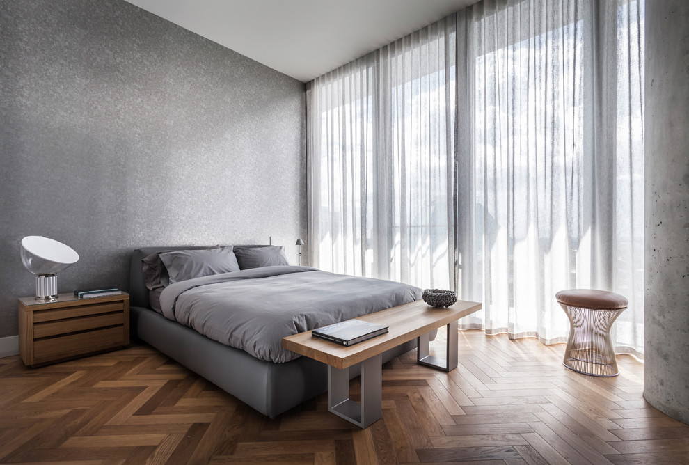 Inspiration for a contemporary grey and brown bedroom in Miami with grey walls, medium hardwood flooring and brown floors.