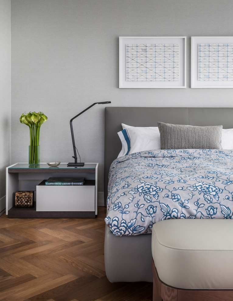 Diseño de dormitorio contemporáneo con paredes grises, suelo de madera en tonos medios y suelo marrón