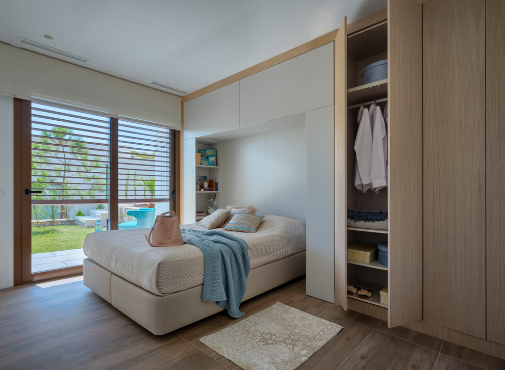 Свежая идея для дизайна: хозяйская спальня среднего размера в стиле модернизм с белыми стенами и коричневым полом без камина - отличное фото интерьера
