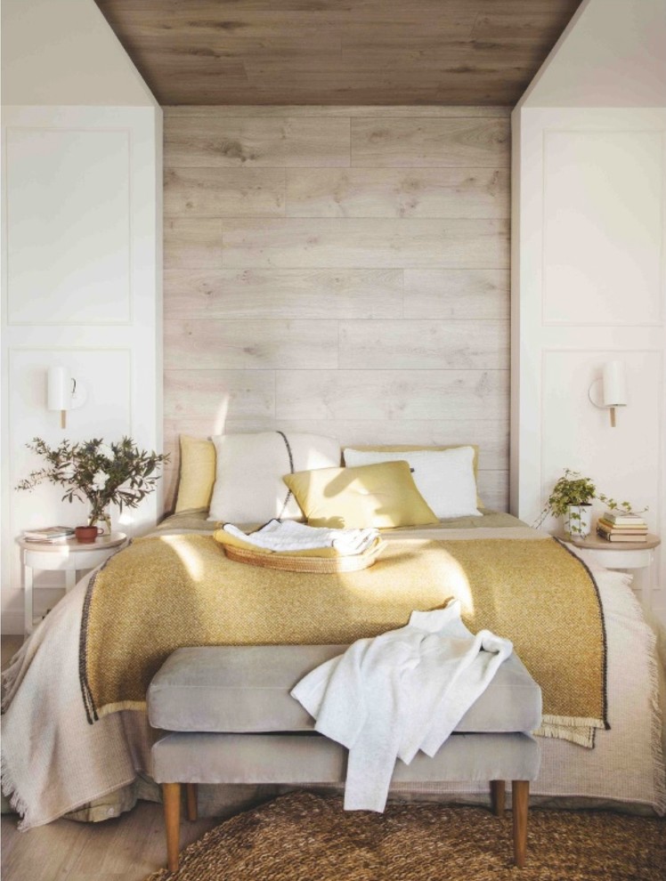 Idée de décoration pour une chambre parentale méditerranéenne de taille moyenne avec un mur blanc, sol en stratifié, aucune cheminée et un sol marron.