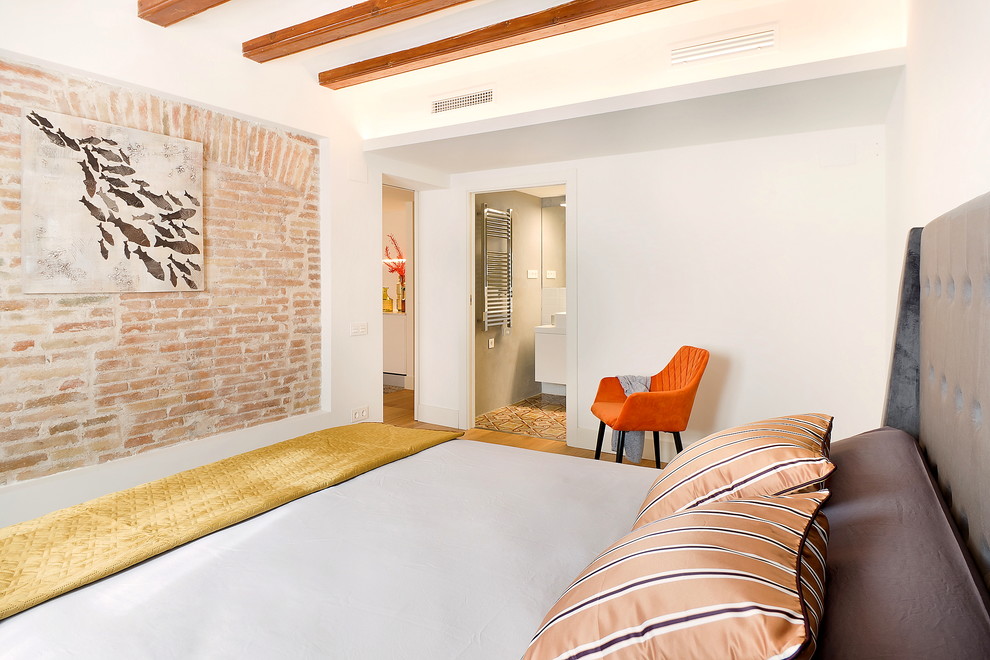 Modelo de dormitorio principal clásico renovado de tamaño medio con paredes blancas y suelo de madera en tonos medios